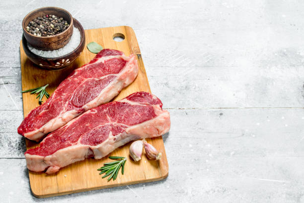 istock Raw beef steaks with spices and herbs. 1141759901
