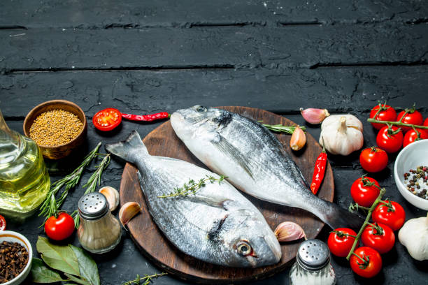 istock Raw sea fish dorado with spices and vegetables. 1141759931