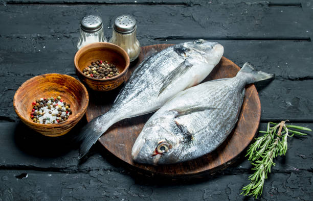 istock Raw sea fish with spices on the cutting Board. 1141759950