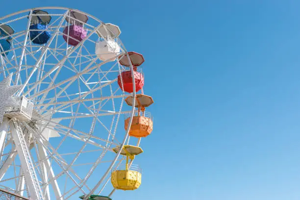 Colourful ferris wheel in the amusement park Tibidabo on background of blue sky, Barcelona, Spain.