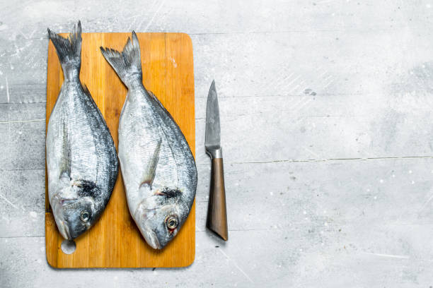 istock Raw sea fish dorado on a cutting Board. 1141762904