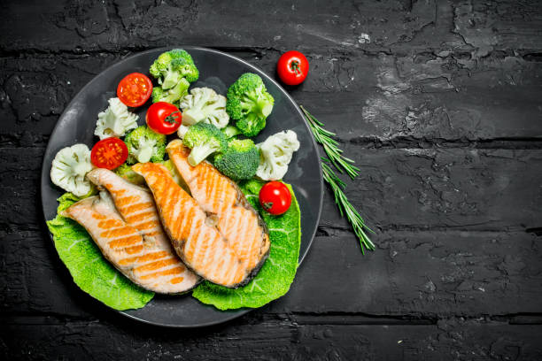 istock Grilled salmon steaks with tomatoes and broccoli in a plate. 1141766231