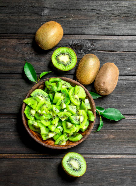 Kiwi slices in the bowl. Kiwi slices in the bowl. On black wooden background kiwi fruit stock pictures, royalty-free photos & images