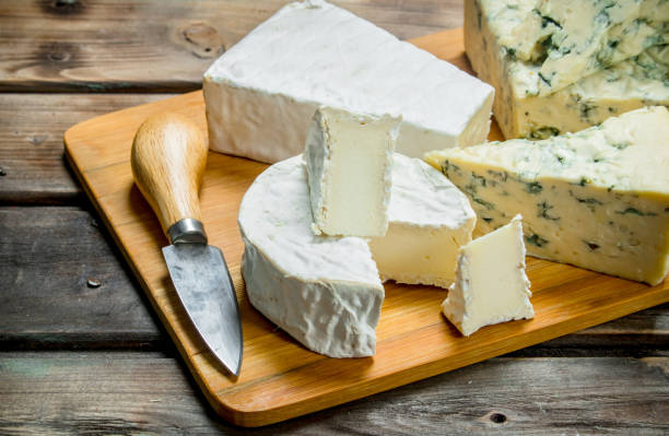 istock Blue and brie cheese on a chopping Board with a knife. 1141767615