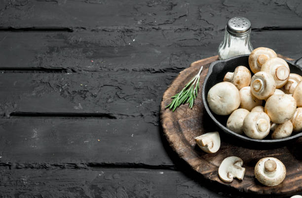 istock Fragrant mushrooms in pan on a cutting Board with salt. 1141767617