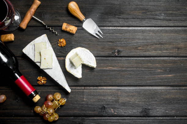 istock Brie cheese with red wine, nuts and grapes. 1141768289