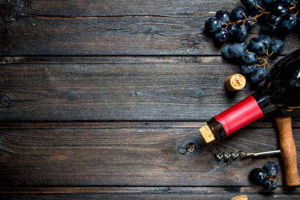 istock bottle of red wine with grapes. 1141769543