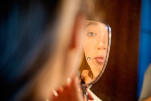 istock Reflection of millennial woman putting make-up. 1141774967