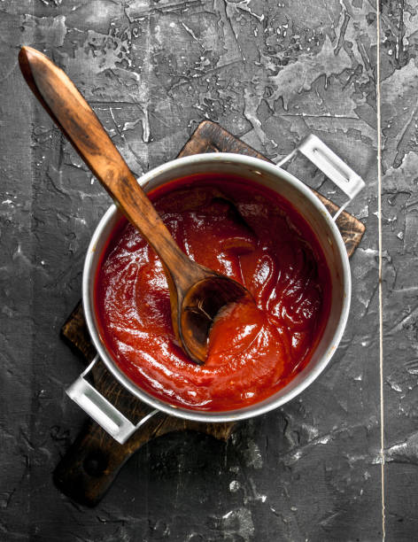istock Tomato sauce in a pot with a wooden spoon. 1141774976