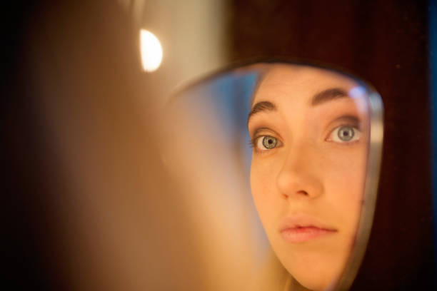 istock Reflection of millennial woman putting make-up. 1141774996