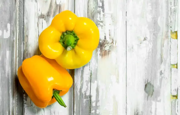 Fresh yellow pepper. On white wooden background