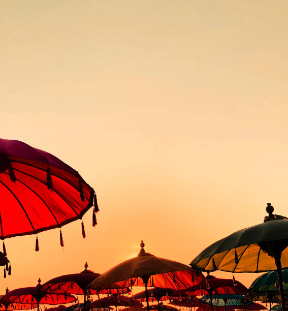 istock Tropical sunset with colorful beach umbrellas 1141775670