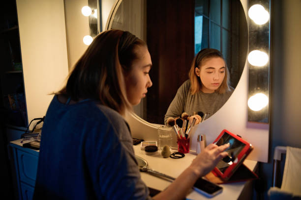 istock Millenial woman doing make-up following a tutorial. 1141775860