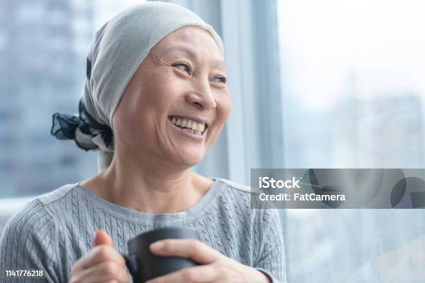 Beautiful Korean Woman With Cancer Looks Out Window Stock Photo - Download Image Now