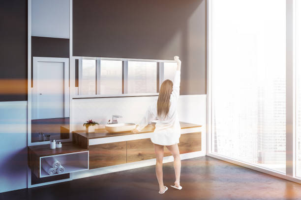 istock Woman in gray bathroom with double sink 1141778891