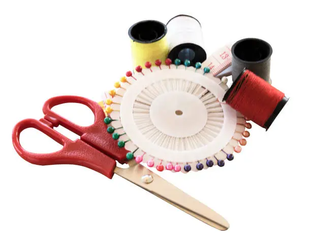 Photo of sewing kit and needles and scissors on white background