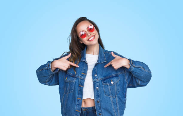 menina feliz que aponta em si mesma - denim jacket - fotografias e filmes do acervo