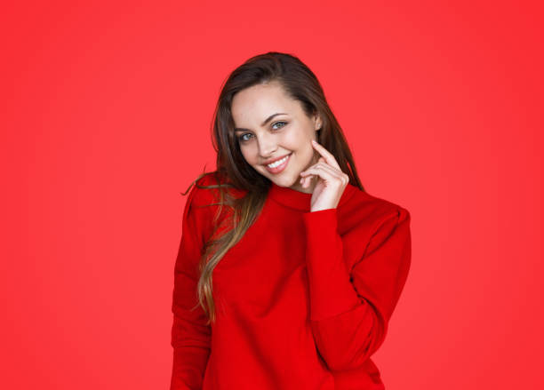 istock Beautiful smiling brunette on red background 1141779914