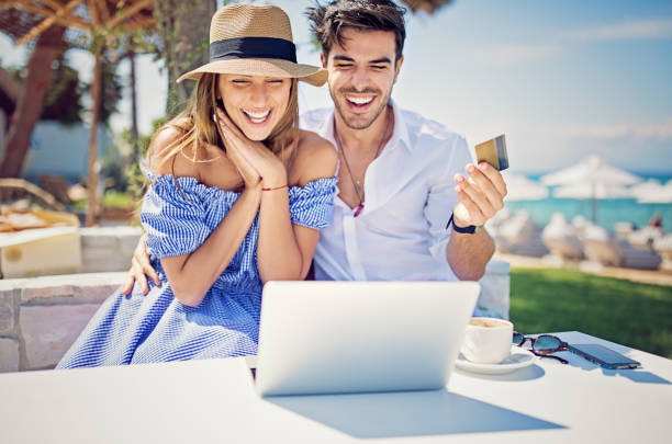 istock Couple is shopping online/making reservation on the beach 1141783076