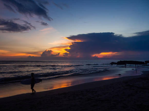 istock Surfers on the background of beautiful sunset clouds 1141785028