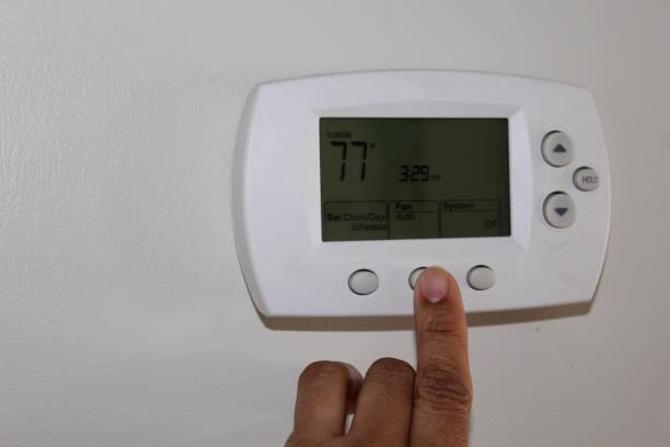 istock A woman adjusting a thermostat 1141786955