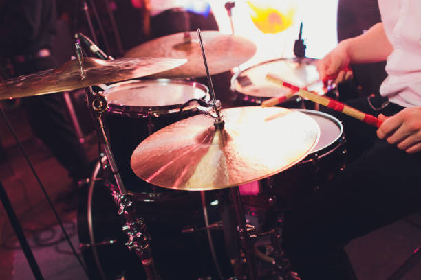 istock Drummer with a drumsticks in his hands playing on drum set on stage on the black background. 1141790084
