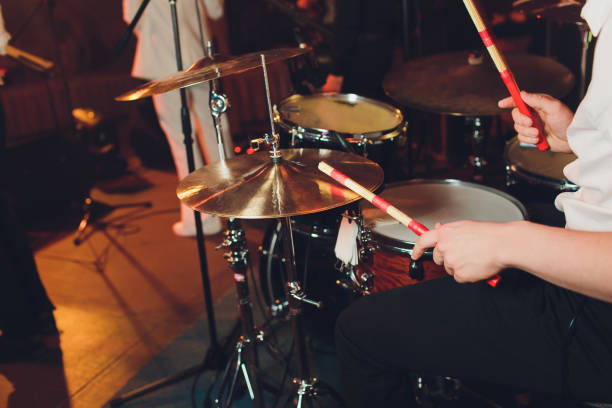 istock Drummer with a drumsticks in his hands playing on drum set on stage on the black background. 1141790085