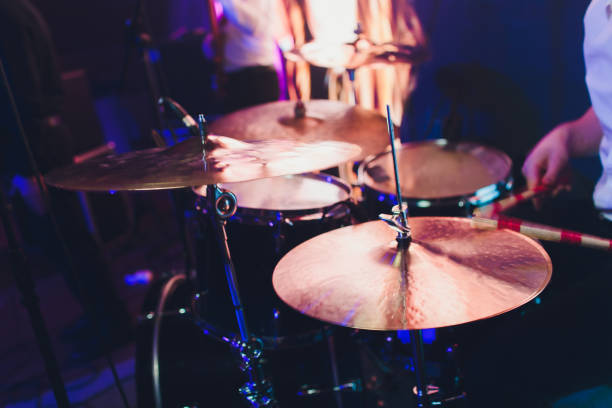 istock Drummer with a drumsticks in his hands playing on drum set on stage on the black background. 1141790088