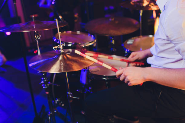 istock Drummer with a drumsticks in his hands playing on drum set on stage on the black background. 1141790090