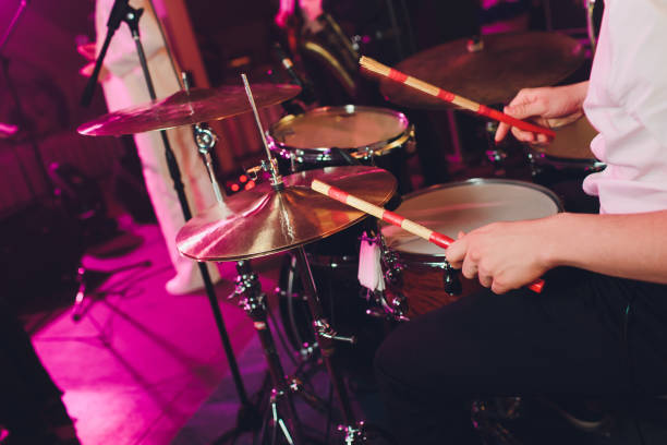 istock Drummer with a drumsticks in his hands playing on drum set on stage on the black background. 1141790092