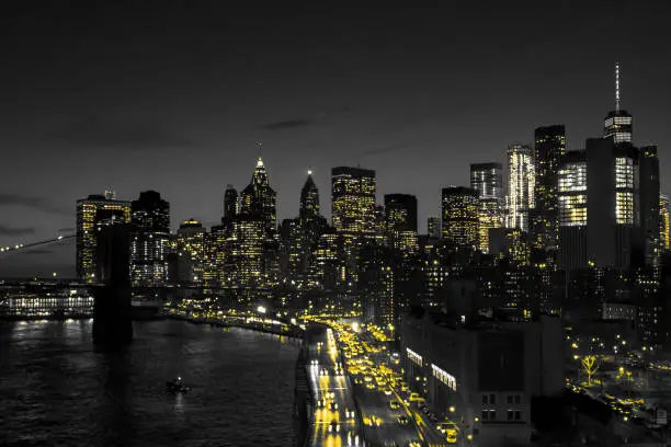 New York City black and white night skyline with golden yellow lights glowing in downtown Manhattan NYC