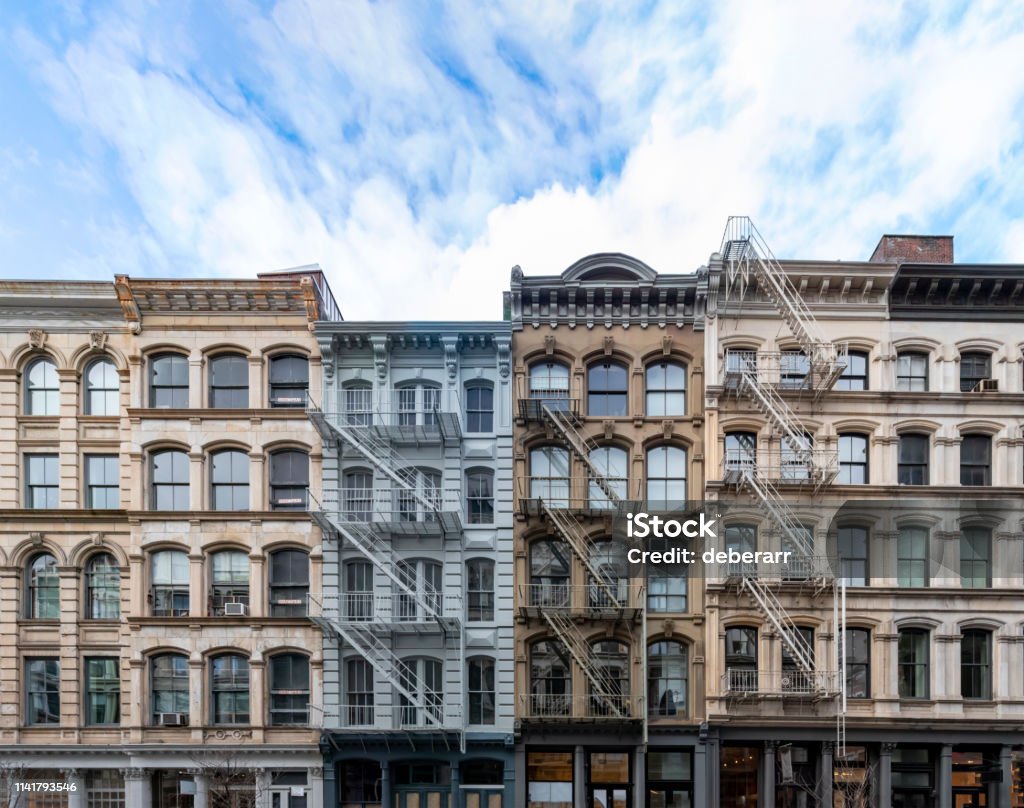 Exterior view of old apartment buildings in the SoHo neighborhood of Manhattan in New York City Exterior view of old apartment buildings in the SoHo neighborhood of Manhattan in New York City with empty blue sky background overhead New York City Stock Photo