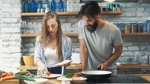 istock Young couple making dinner together at home 1141793562