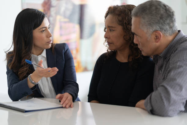 Ethnic Senior Couple With Financial Advisor A black couple are in a meeting with their financial advisor. They are devising a financial plan to send their kids to university at their kitchen table. will legal document photos stock pictures, royalty-free photos & images