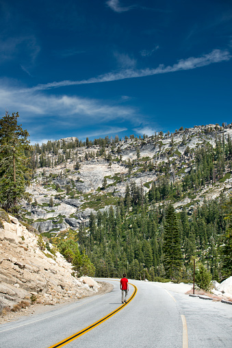 Man walking alone on a highway. Tramping at around Yosemite National Park