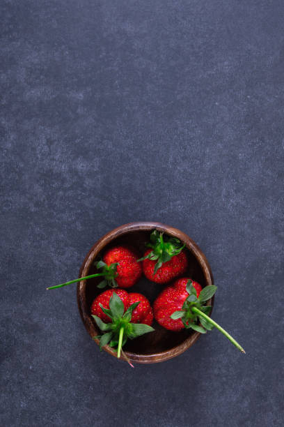 Fresh strawberries on black stone