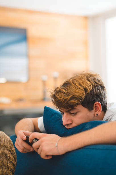 Young man playing video game on smart phone