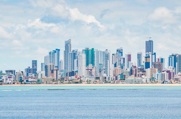 Seafront city, Joao Pessoa Seafront city. Touristic city with a beach, banks of corals on the sea at low tide and tall buildings on background. Praia do Bessa beach at the city of Joao Pessoa. joão pessoa photos stock pictures, royalty-free photos & images