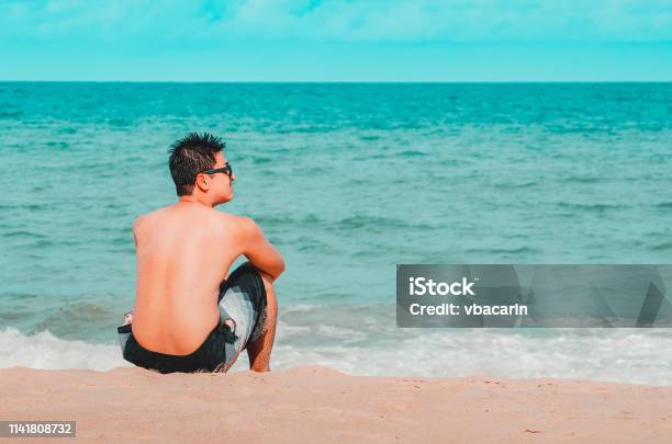 Man Seated On The Sand Of The Beach Stock Photo - Download Image Now - João Pessoa, Paraiba, Beach