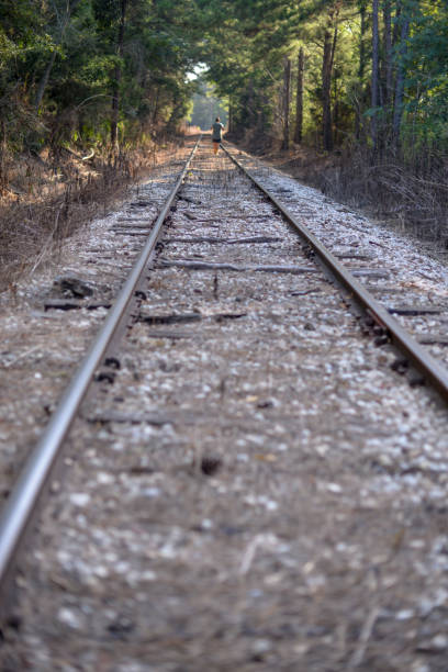 istock Woman walking in distance on train track 1141810343