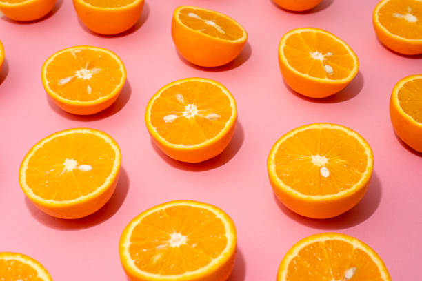 istock Orange juicy oranges split in half on pink 1141811173