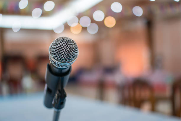 istock Microphone on abstract blurred conference hall prepare for speaker on stage in seminar room. lecture to audience university with bokeh background. Business meeting or education teaching image 1141817445