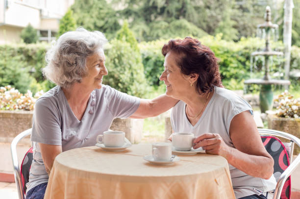 istock Senior women drinking coffee and laughing 1141820638