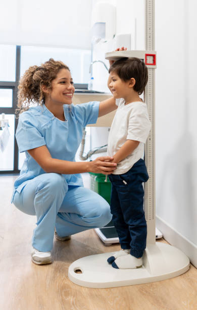 ラテンアメリカの看護師は、hos 成長の進行状況を確認する小児科患者を測定します笑顔 - patient medical occupation cheerful latin american and hispanic ethnicity ストックフォトと画像