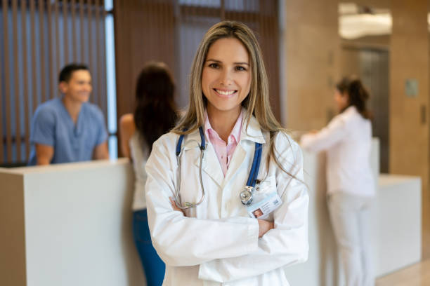 exitosa doctora latinoamericana que enfrenta cámara sonriendo con los brazos cruzados - nurse doctor healthcare and medicine latin american and hispanic ethnicity fotografías e imágenes de stock