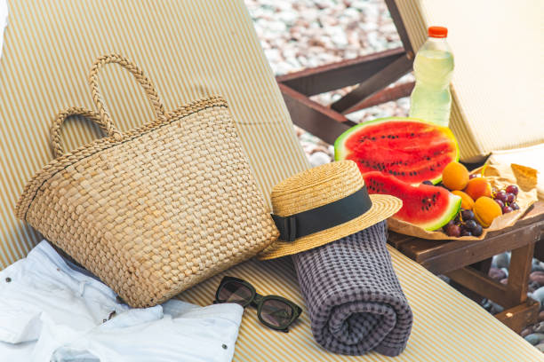 plage stuff sac serviette couverture sur le soleil plus longtemps. fruits sur la table. vacances - beach table peach fruit photos et images de collection