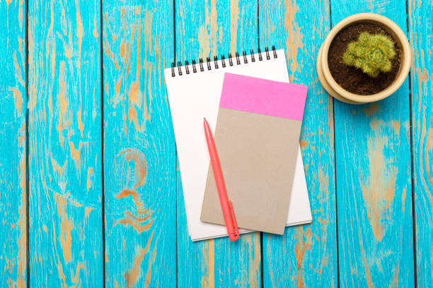 istock Top view workspace with blank notebook and pen on wooden table background 1141845677