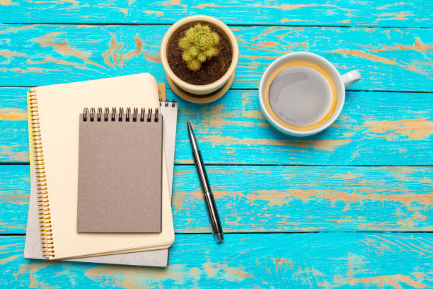 istock Cup of coffee with notebook on wooden desk 1141845779