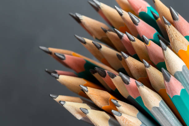 Red pencil amongst greyed out pencils conceptual