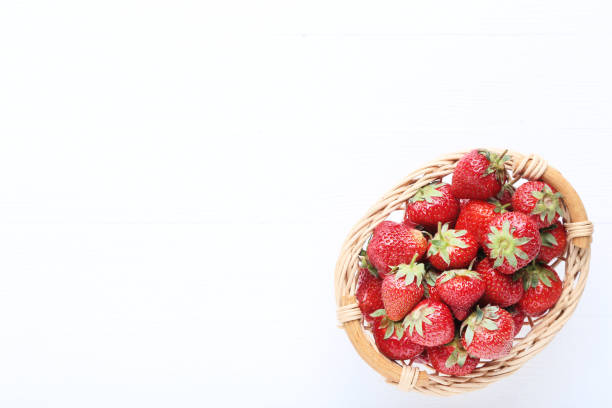istock Fresh strawberries in basket on white wooden table 1141850530